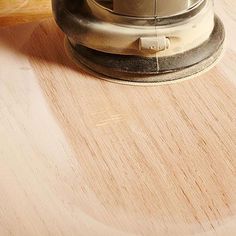 a person using a sander on top of a wooden table next to a knife