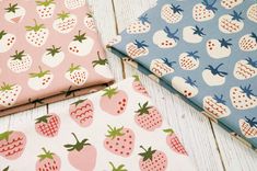 three different types of fabric with strawberries and pineapples on them, one in pink, the other in blue