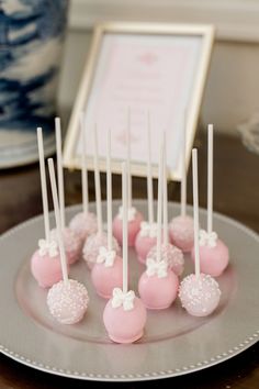 pink and white cake pops on a silver plate