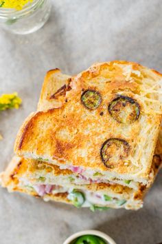 a sandwich cut in half sitting on top of a table next to a bowl of pickles