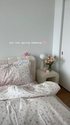 a bed with white sheets and pink flowers on it