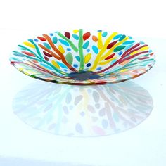 a colorful glass bowl sitting on top of a white table