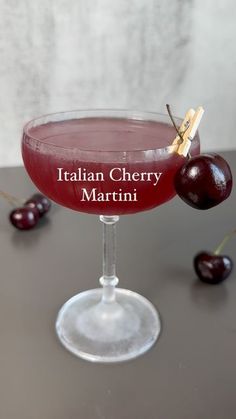 a close up of a wine glass on a table with cherries