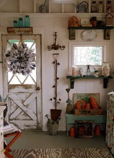 a living room filled with furniture and lots of shelves next to a door that has a clock on it