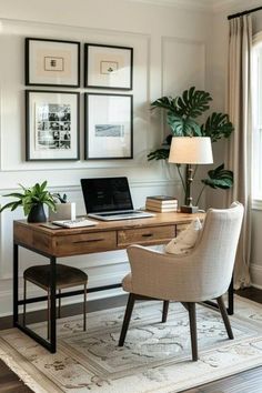 a desk with a laptop computer on top of it next to a chair and potted plant