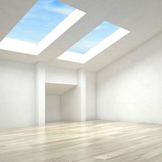 an empty room with two skylights in the ceiling and wood floors on either side