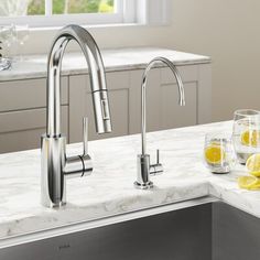 a stainless steel kitchen sink with chrome faucet and two lemons on the counter