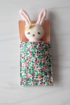 a stuffed animal in a pocket with flowers on it's back and ears sticking out