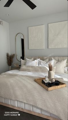 a bed with white linens and pillows in a small room next to a mirror