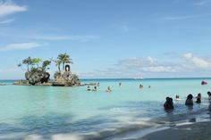 people are swimming in the ocean near an island