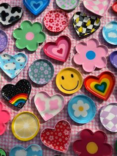 many different colored hearts and smiley faces on a table