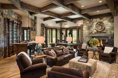 a living room filled with furniture and a fire place in the middle of a room