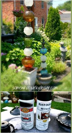 some paint bottles sitting on top of a table in front of a house with flowers