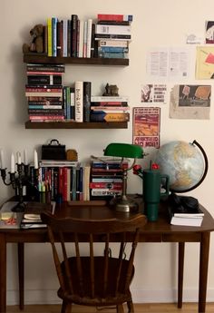 a wooden desk topped with books next to a book shelf filled with lots of books