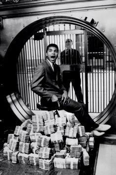 a man sitting on top of a pile of money in front of a jail cell