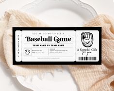 a baseball game ticket sitting on top of a white plate next to a pink napkin