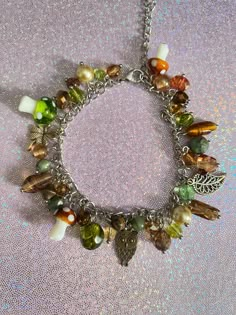 Add a touch of nature to your dream aesthetic with this mushroom charm bracelet! With earthy colors and elements such as green & brown mushrooms, a leaf, an owl, a clover, this charm bracelet will never fade from its original colors. Check out our charm bracelets section for more unique designs! Product info: *Made with stainless steel materials only (except charms that are regular metal) *Adjustable, reaches up to 6.5 inches *Charm materials consist of metal and glass If you have any questions, please don't hesitate to ask! We are friendly:) Visit our official website: www.yeetincolorboutique.com and follow us on Instagram: @yeetincolorboutique Gremlin Core, Shifting Wardrobe, Dr Belongings, Fairy Things, Cottagecore Jewelry, Mushroom Jewelry, Dream Aesthetic, Leaf Bracelet, Spend Money