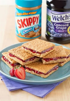 a blue plate topped with crackers and strawberry jam