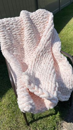 a pink blanket sitting on top of a metal chair