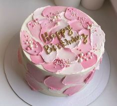 a birthday cake with pink and white frosting