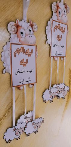 two sheep on sticks with signs attached to them that say, eid al - adha