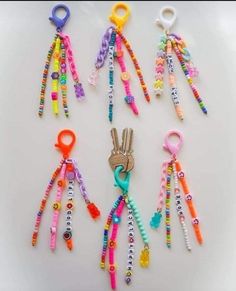 several pairs of colorful beaded keychains on a white surface