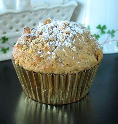 a muffin sitting on top of a table covered in powdered sugar