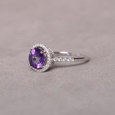 This is a 7mm natural amethyst birthstone ring set in solid sterling silver and with rhodium plated. The ring features a clear round faceted natural amethyst and lots of tiny zircon around of the main stone. If you want other size, please contact me to order and it will take 7-10 days to finish. The item is sent in a beautiful gift box You can realize more lovely stuff clicking the link https://www.etsy.com/shop/knightjewelry?refshopsection_shophome_leftnav Anniversary Brilliant Cut Round Gemstones, White Gold Sterling Silver Gemstones With Round Stone, Classic Round Cut Ruby Promise Ring, Classic Round Cut Promise Ring Gemstones, Classic Round Cut Ruby For Promise Ring, Fine Jewelry Round Stone With Prong Setting, Cubic Zirconia Anniversary Gemstone Round Cut, Round Diamond Gemstones For Promise Ring, Fine Jewelry Round Stone Gemstones With Prong Setting