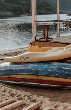 two canoes are sitting on the sand near water