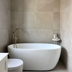 a white bath tub sitting next to a toilet