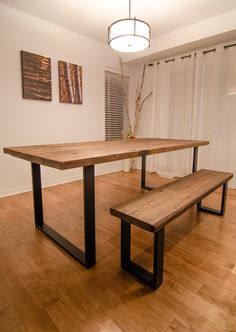 a wooden table with two benches in front of it on top of a hard wood floor