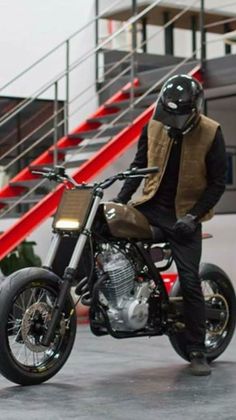 a man is sitting on a motorcycle in front of some stairs