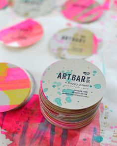 several round coasters sitting on top of a table covered in paint splattered paper