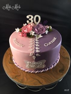 a pink and purple cake with flowers on top