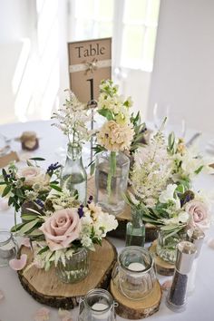 a table topped with vases filled with flowers