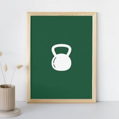 a green poster with a white kettle on it next to a vase and some flowers