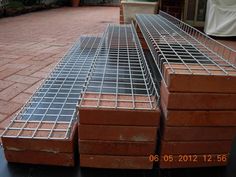 several bricks stacked on top of each other in front of a brick building with metal grating