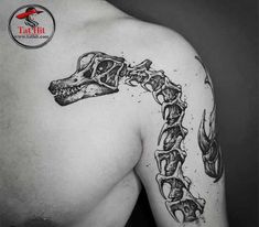 a man's back with a skeleton and bones tattoo on his shoulder, which has the