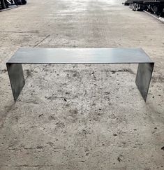 a metal table sitting on top of a dirt field