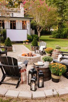 an outdoor patio with chairs, fire pit and potted plants