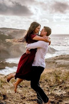 a man and woman are hugging on the beach