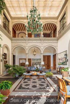 a large living room filled with furniture and potted plants