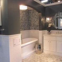 a bathroom with a tub, sink and mirror is shown in this image from the front view