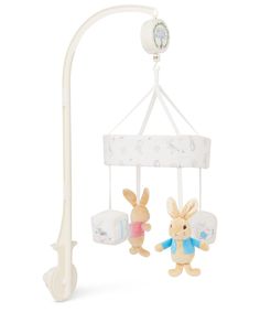 a baby crib mobile with two stuffed animals hanging from it's sides and a lamp on the other side