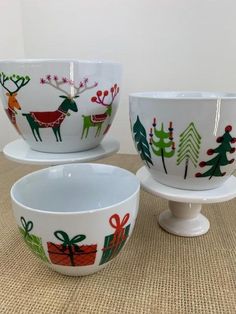 three white bowls with christmas designs on them