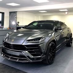 a grey lamb suv parked in a showroom