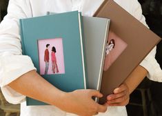 a person holding three books in their hands