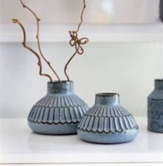 two blue vases sitting on top of a white counter