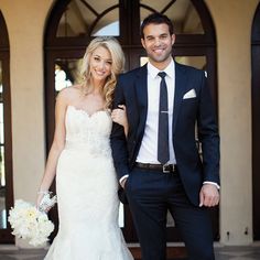 a bride and groom standing in front of a building