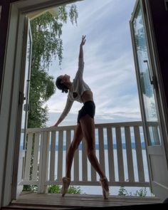 a woman standing on a porch with her arms in the air